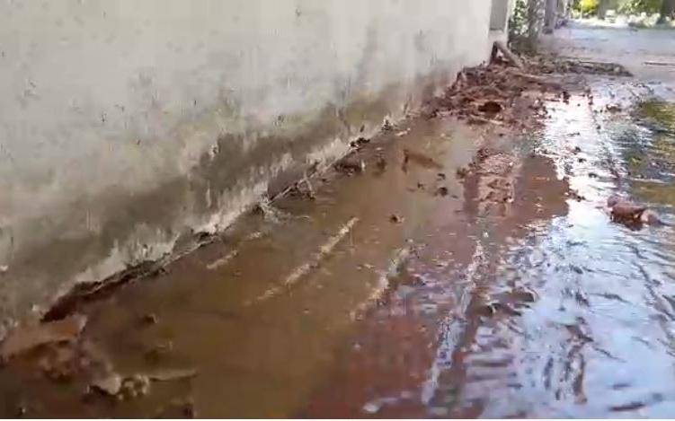 En El Mondongo brota agua hacia la vereda de la pared exterior de una casa