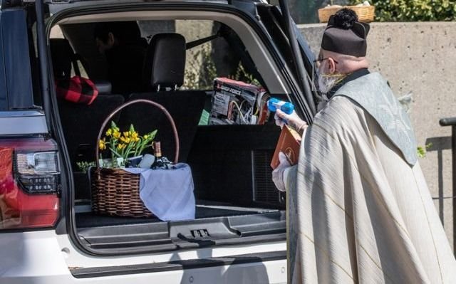 Cuestión de fe y seguridad: sacerdote usa una pistola de agua para bendecir a sus fieles