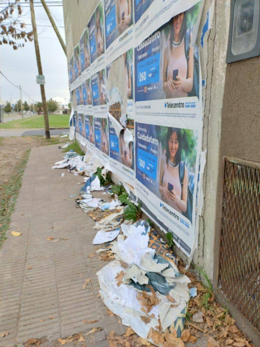 En 25 y 528, afiches en la pared y basura en la vereda