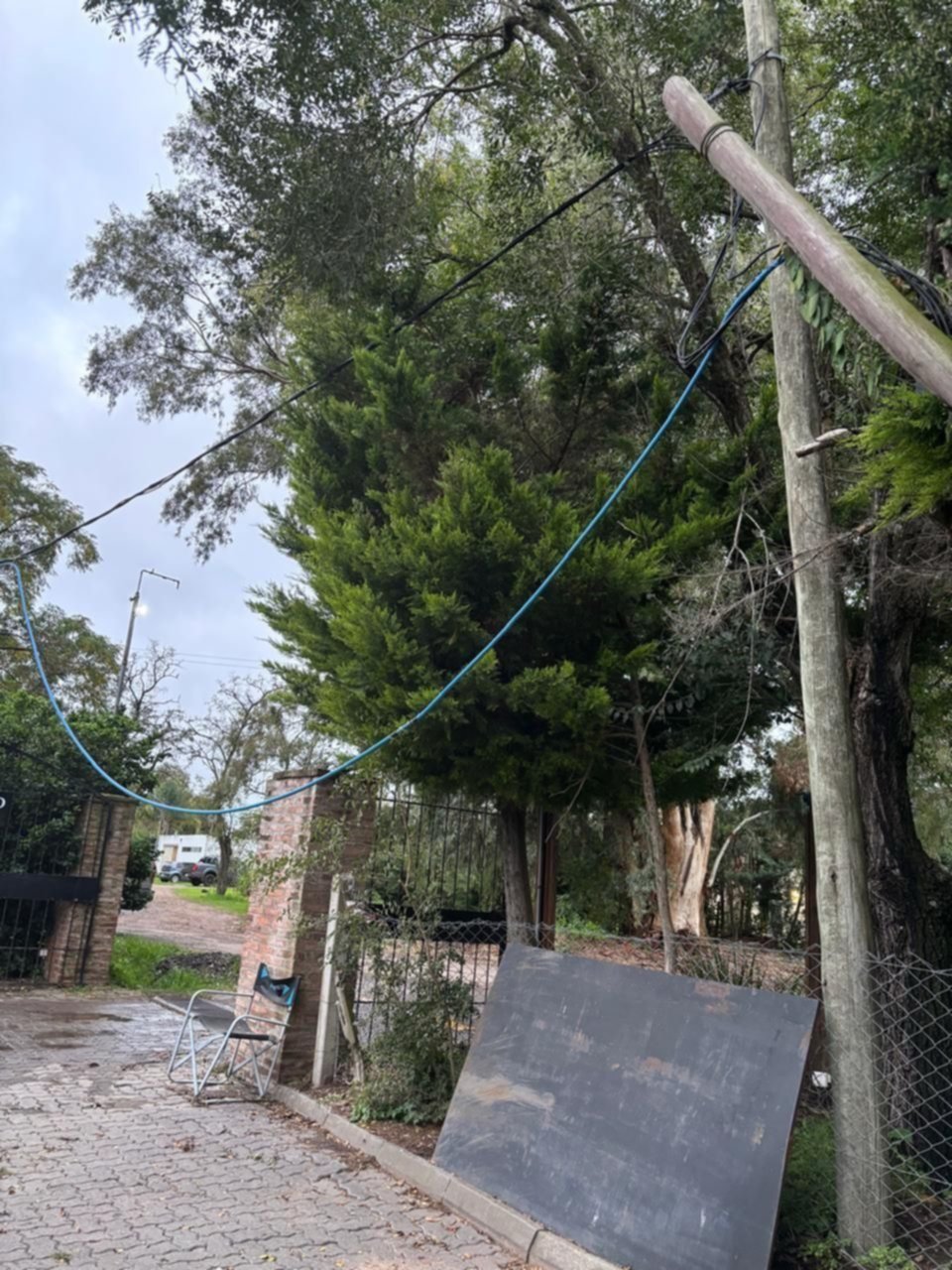 Reclamo por un poste semi caído y un cable colgando en City Bell