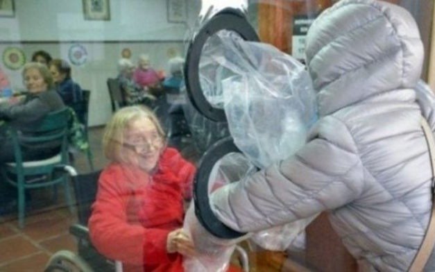 Adultos mayores de un geriátrico dan abrazos a sus seres queridos a través de un nylon