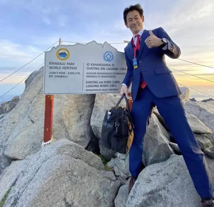 Escaló la montaña más alta de Malasia trajeado y con corbata