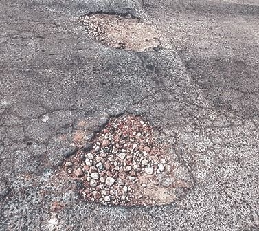 Una calle con pozos en pleno centro de Los Hornos