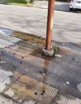 Más riesgo no se consigue: una pérdida de agua en la base de un poste de luz
