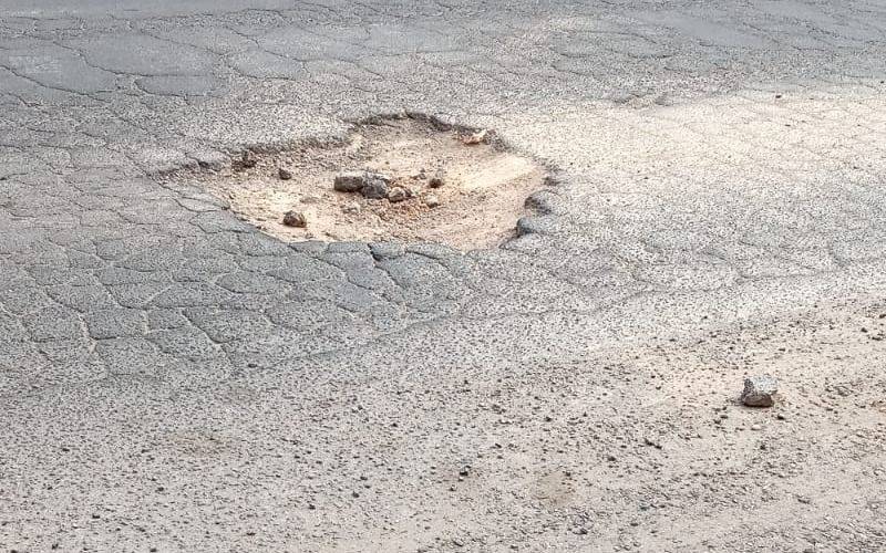 Un bache provoca que con el paso de los autos las piedras "salten a la vereda"