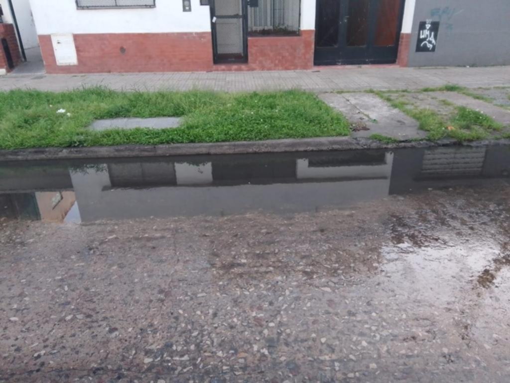 Una laguna en una cuadra con un colegio y una iglesia