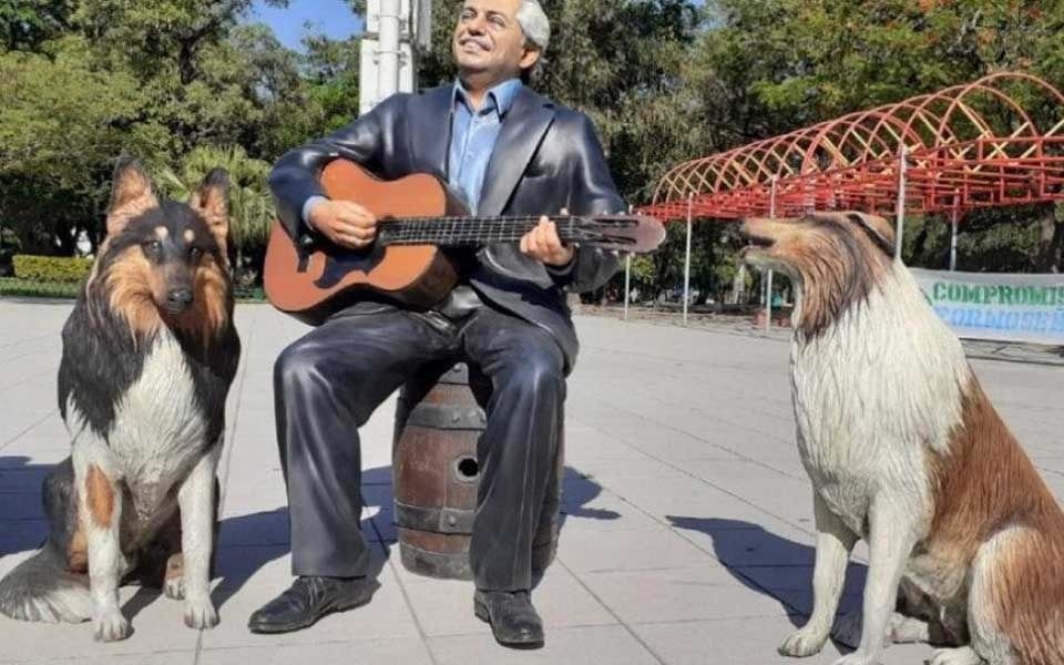 Tocando la guitarra y con los perros: la estatua de Alberto Fernández en una plaza