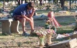 Tristeza: la imagen de un padre escuchando un partido de fútbol en la tumba de su hijo