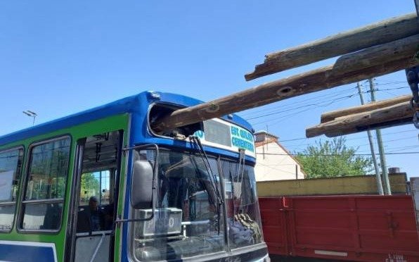Un colectivo quedó atravesado por postes de un camión