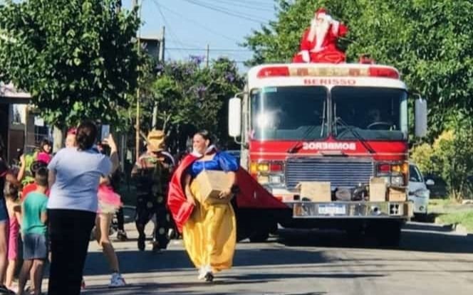 Papa Noel en el autobombas de bomberos repartió golosinas en Berisso